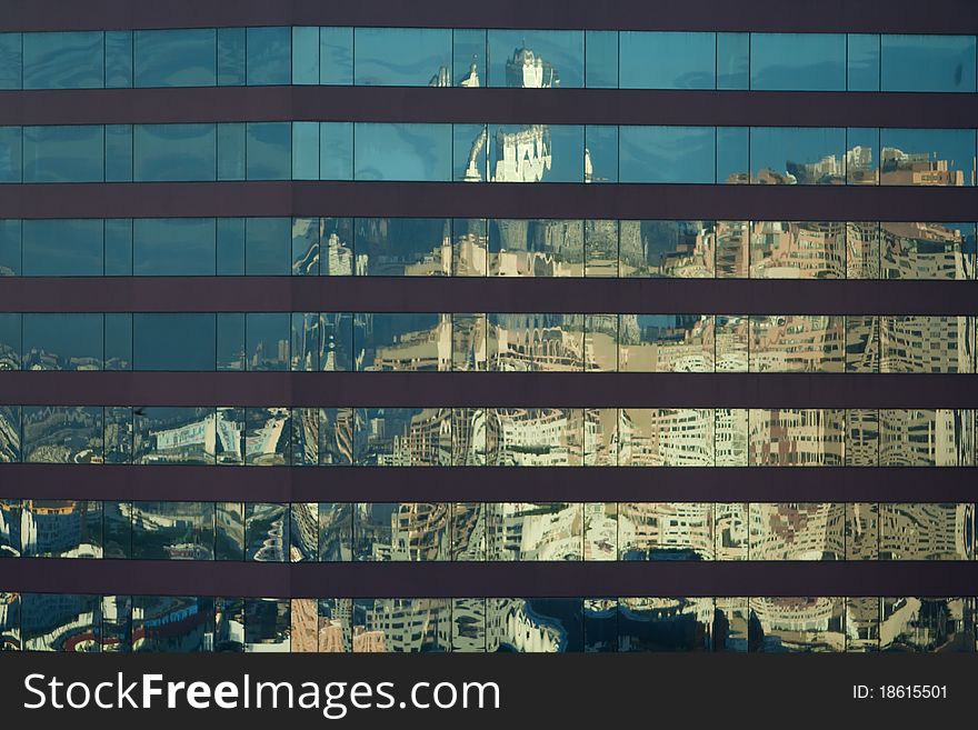 Angled shot of an office building with shiny blue glass facade on a sunny day.