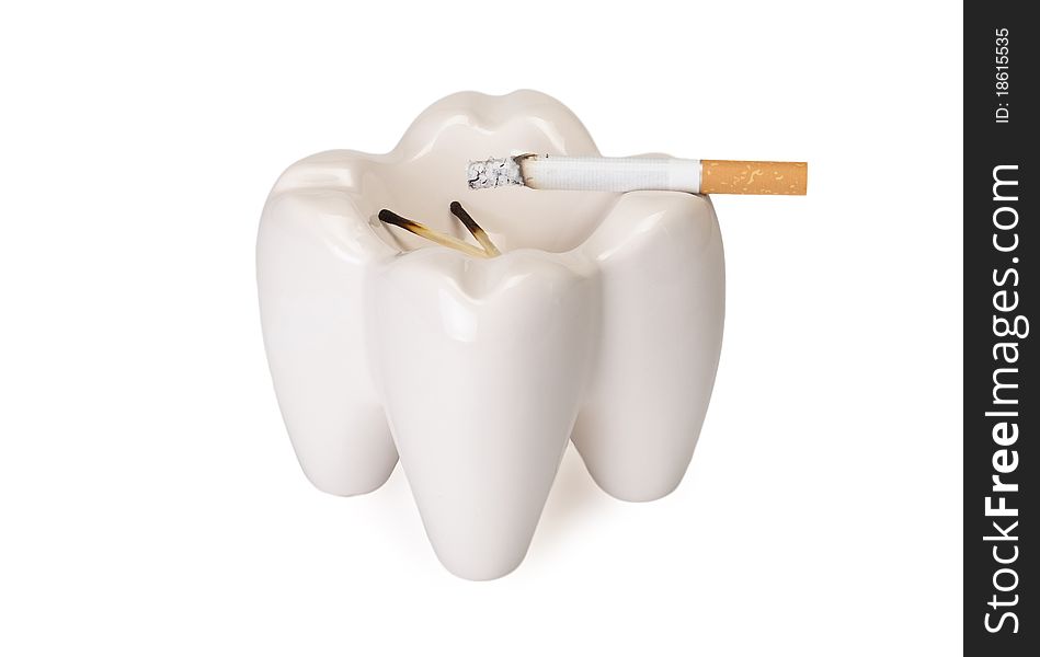 Ashtray in the form of a tooth with a stub on a white background