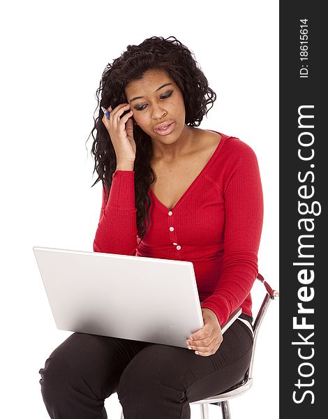 An African American woman is thinking and holding a computer. An African American woman is thinking and holding a computer.