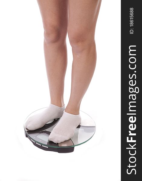 A woman with her legs on the bathroom scales, wearing socks. A woman with her legs on the bathroom scales, wearing socks.