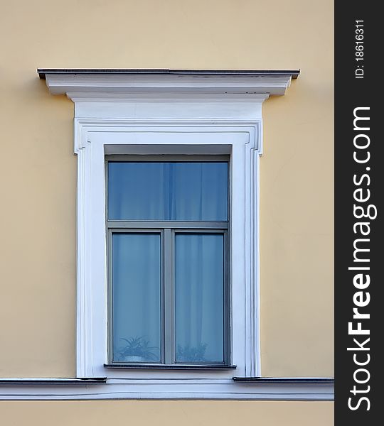 Old window on the yellow wall in the Classical style. Old window on the yellow wall in the Classical style