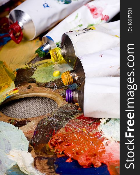 Artistic equipment: paint, brushes and knives on paint background