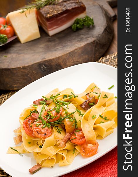 Photo of delicious pasta with bacon and tomatoes