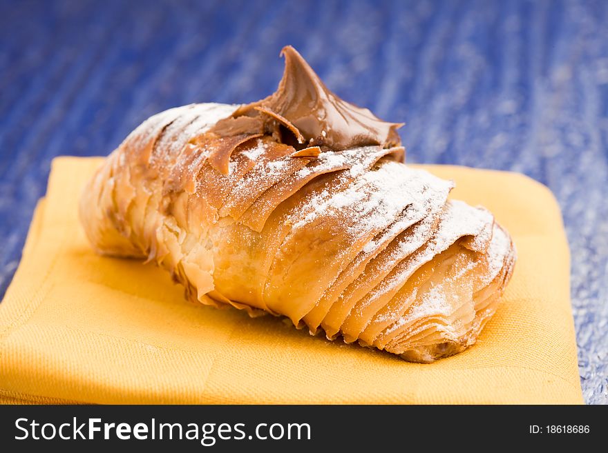 Photo of delicious pastries with soft choccolate on yellow cloth