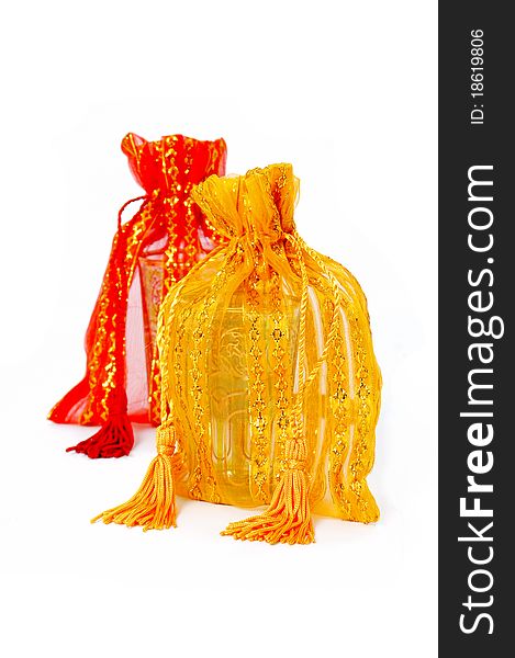 Shimmering yellow and red fabric bags, embellished with gold thread and string ties