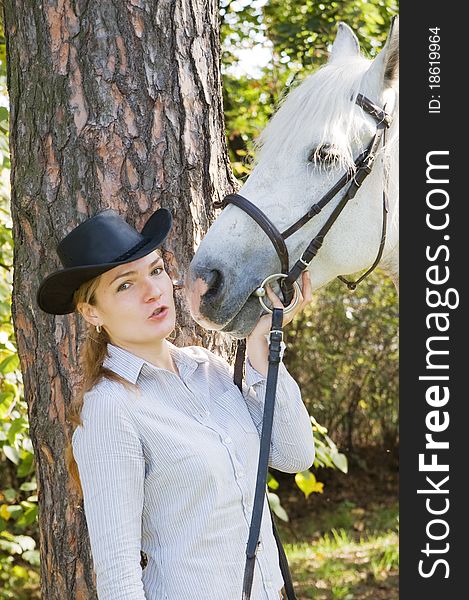Portrait of young woman with her white horse in the woods. Portrait of young woman with her white horse in the woods