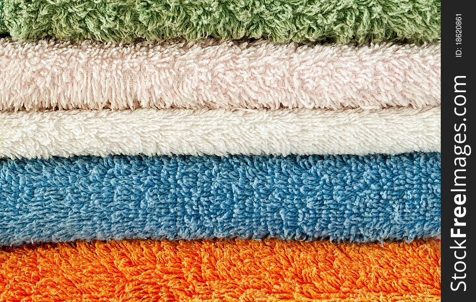 Towels of different colors stacked in a pile