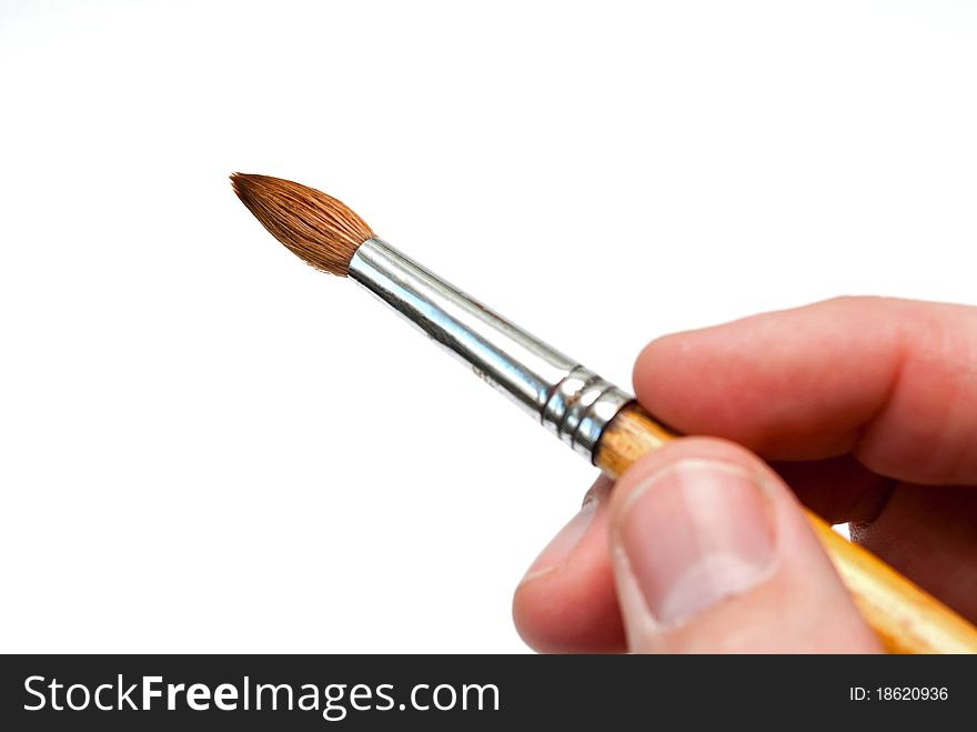 Brush to paint in his hand on a white background. Brush to paint in his hand on a white background