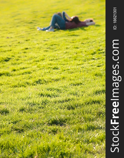 Teen couple lying on a fresh patch of green grass in the sunset light. Concept about ecology and healthy lifestyle. Teen couple lying on a fresh patch of green grass in the sunset light. Concept about ecology and healthy lifestyle.