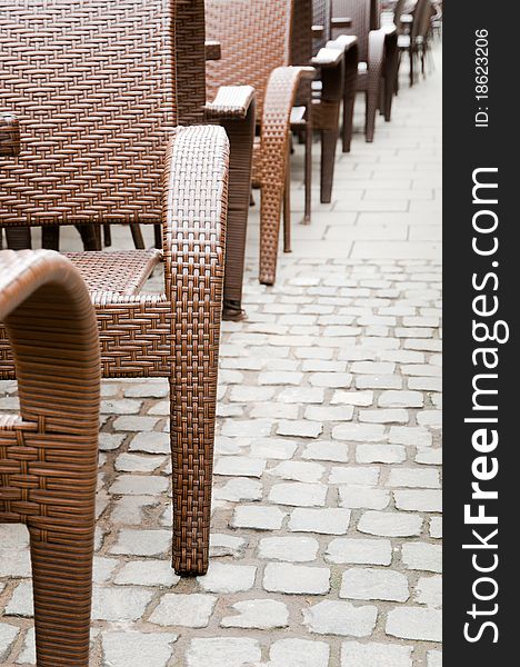 Sidewalk cafe wicker chairs in a row, on a street in the historical center of Bucharest. Sidewalk cafe wicker chairs in a row, on a street in the historical center of Bucharest.