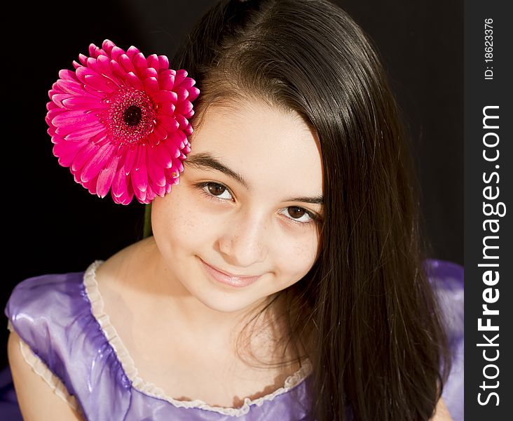 Cute girl with pink flower. Shoot in studio