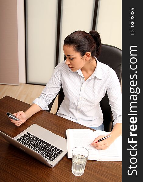 Young woman working on a laptop in the office. Young woman working on a laptop in the office.