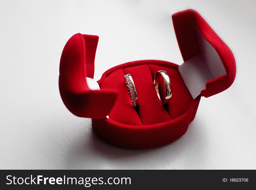 Heart-shaped red box with two gold wedding rings