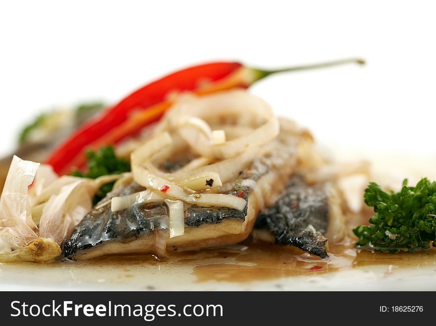 Studio close-up photography of a herring marinated with onions and peppers