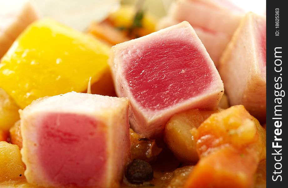 Close up studio shooting of a tuna with sauteed vegetables