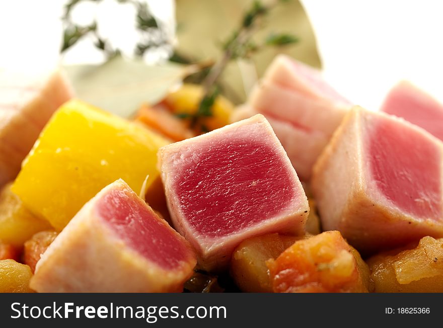 Close up studio shooting of a tuna with sauteed vegetables