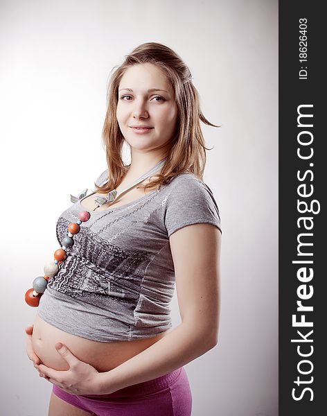 Funny pregnant woman in bright clothing and beads