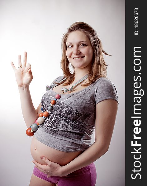 Funny pregnant woman in bright clothing and beads
