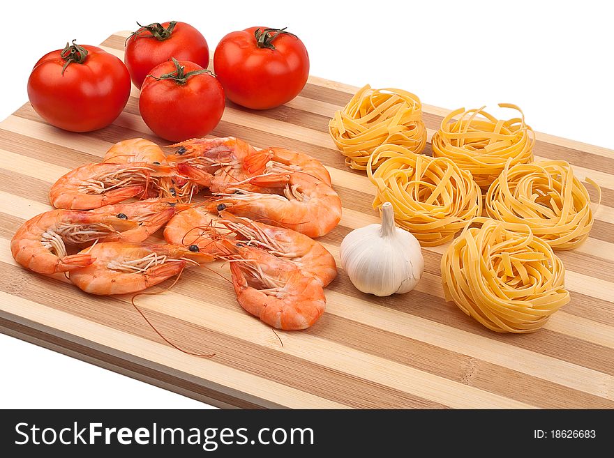 Shrimps, tomatoes, garlic and pasta on wooden tray. Shrimps, tomatoes, garlic and pasta on wooden tray