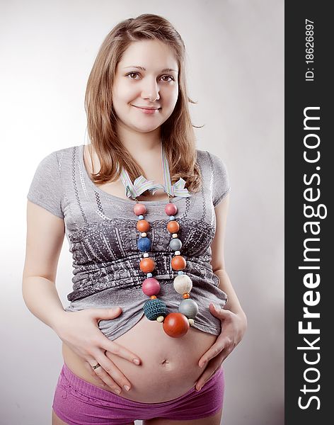 Funny pregnant woman in bright clothing and beads