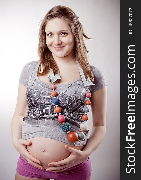 Funny pregnant woman in bright clothing and beads