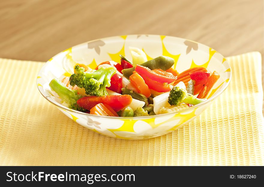 Sliced vegetables in a bright plate ona yellow cloth