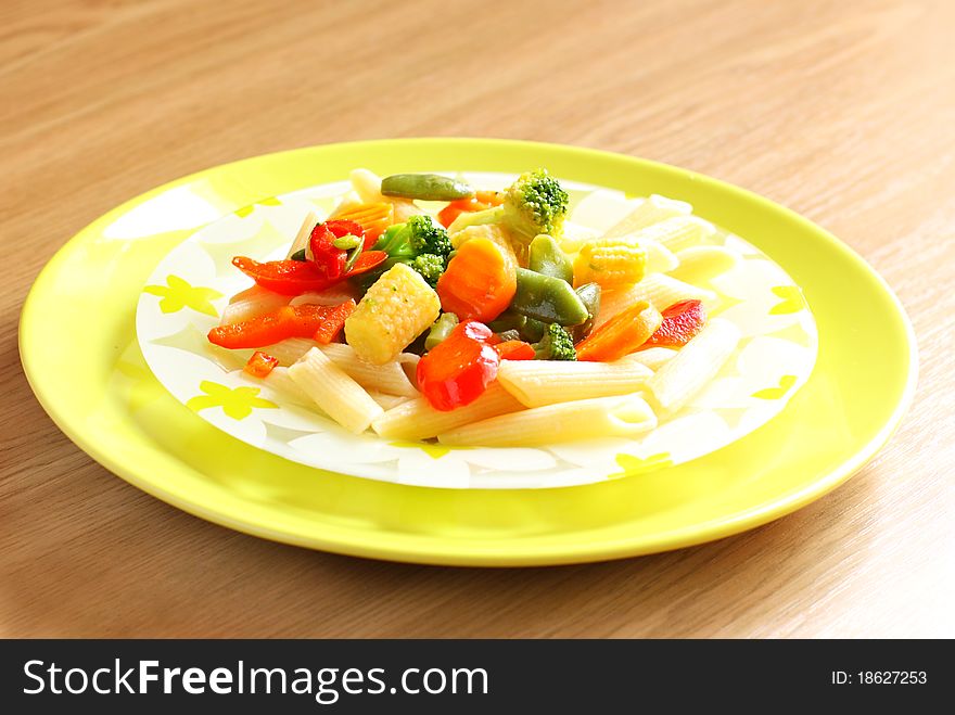 Sliced vegetables in a bright plate on a wooden surface