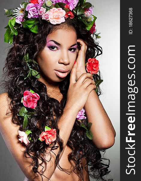 Elegant mulatto girl with circlet of flowers