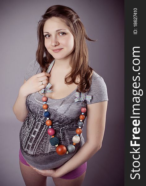 Funny pregnant woman in bright clothing and beads