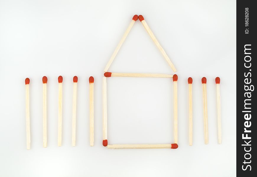 Red matches demonstrating a house with a fence. Red matches demonstrating a house with a fence.