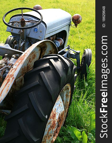 Oldtimer tractor, wrecked on a green lawn