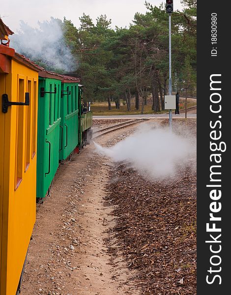 An old steam train pulls colorful waggons