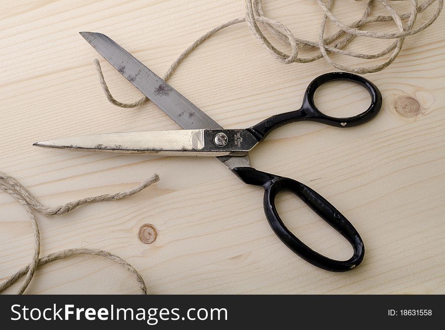 Scissors cut a piece of string near