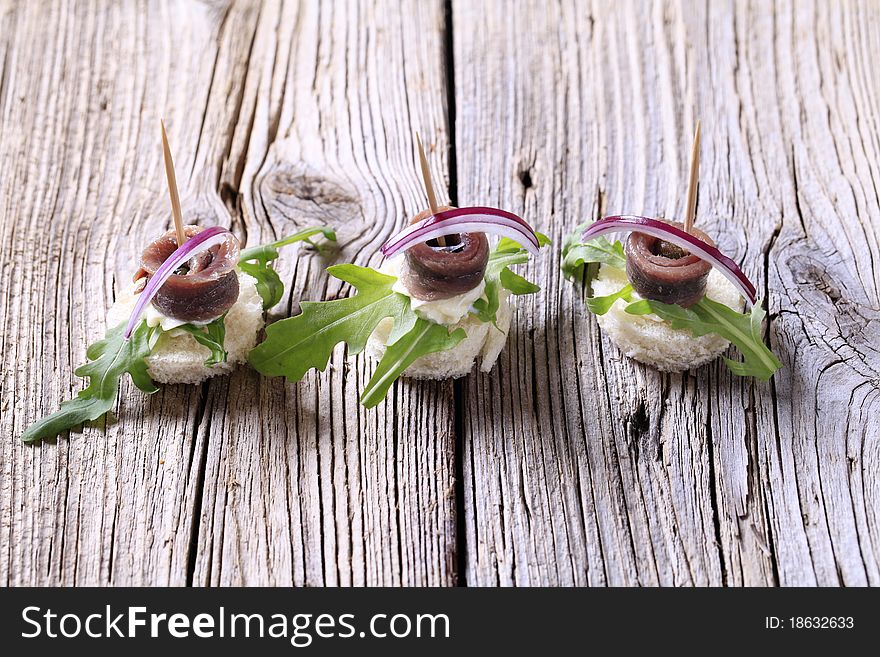 Anchovy canapes garnished with greens and onion