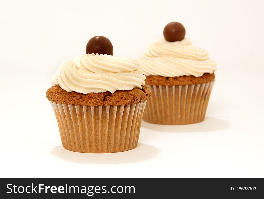 Chocolate malt cupcakes with frosting and candy on a white background. Chocolate malt cupcakes with frosting and candy on a white background