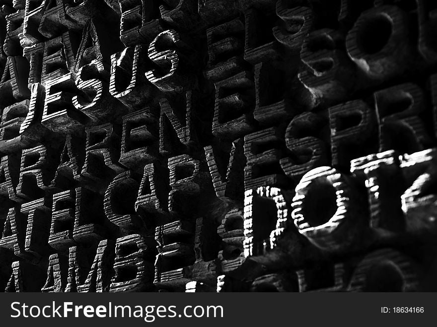 The carved wooden door of Gaudi's Sagrada Familia - close-up with the word Jesus (black and white). The carved wooden door of Gaudi's Sagrada Familia - close-up with the word Jesus (black and white)