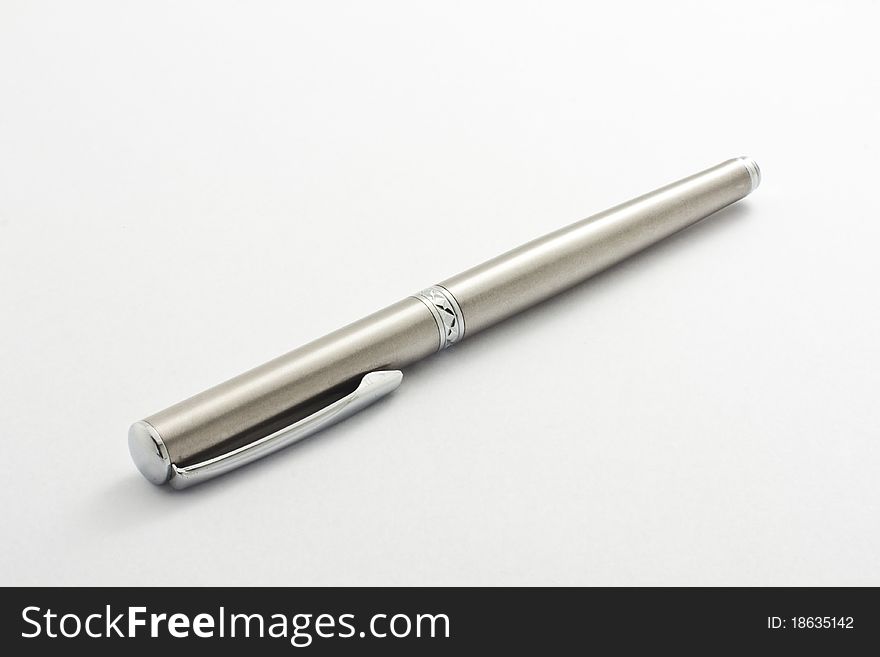 Silver pen is placed on a white background.
