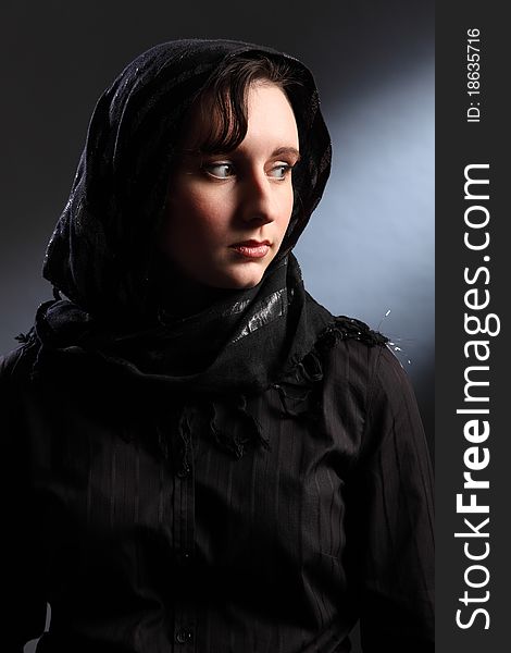 Tranquil portrait of beautiful young woman wearing black hijab, looking away over her shoulder. Tranquil portrait of beautiful young woman wearing black hijab, looking away over her shoulder.