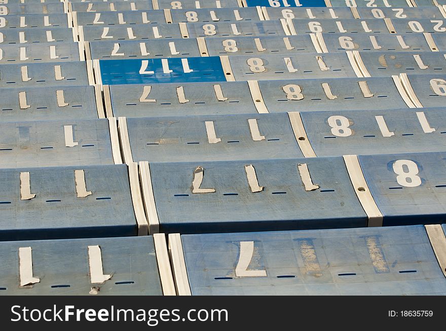 A row of blue seats showing numbers from 117 to 120. A row of blue seats showing numbers from 117 to 120