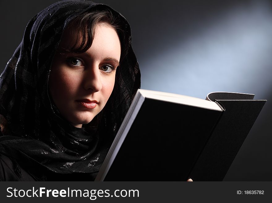 Peaceful prayer time for beautiful young woman wearing black headscarf studying the bible. Peaceful prayer time for beautiful young woman wearing black headscarf studying the bible.