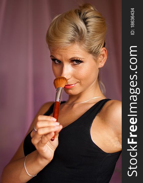 Beautiful girl holding a professional paintbrush for make-up. Beautiful girl holding a professional paintbrush for make-up