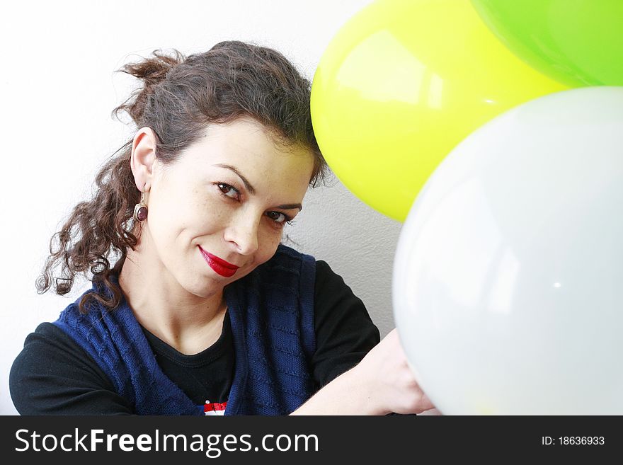 Woman holding balloons smiling looking at the camera