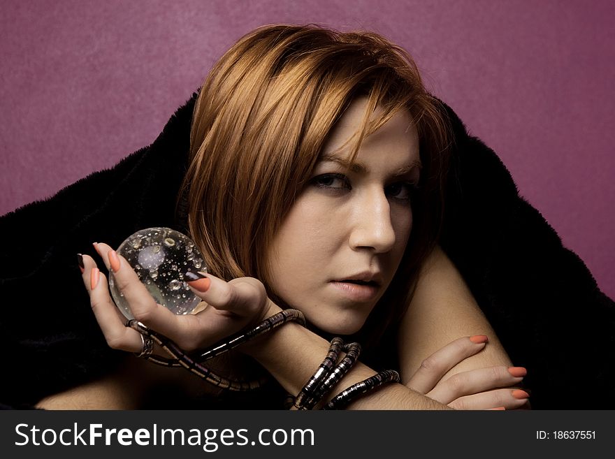 View of a beautiful woman on the bed with a transparent glass ball. View of a beautiful woman on the bed with a transparent glass ball.