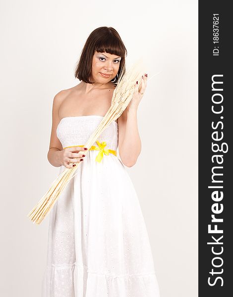 Beautiful brunette girl with ears of wheat in her hair isolated on the white background