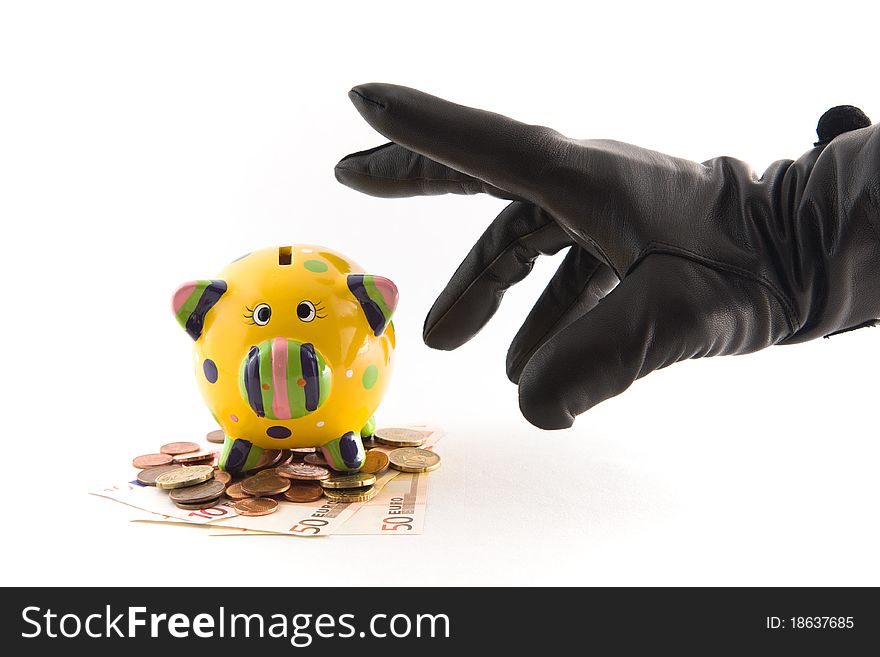 A piggy bank with money being stolen by a hand with black glove. A piggy bank with money being stolen by a hand with black glove