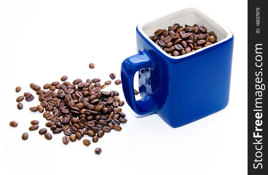Dark blue cup with coffee grains on a white background. Dark blue cup with coffee grains on a white background