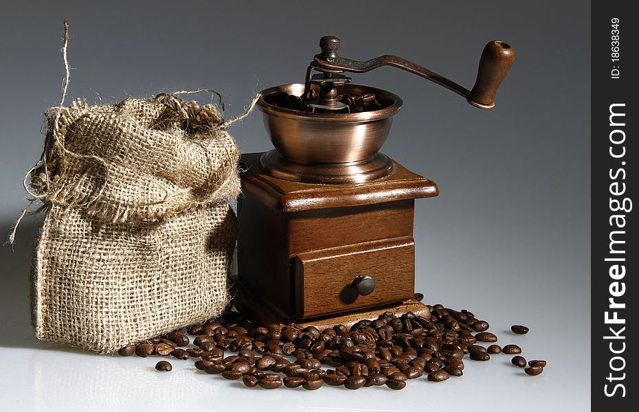 Coffee mill with a sack of roasted beans