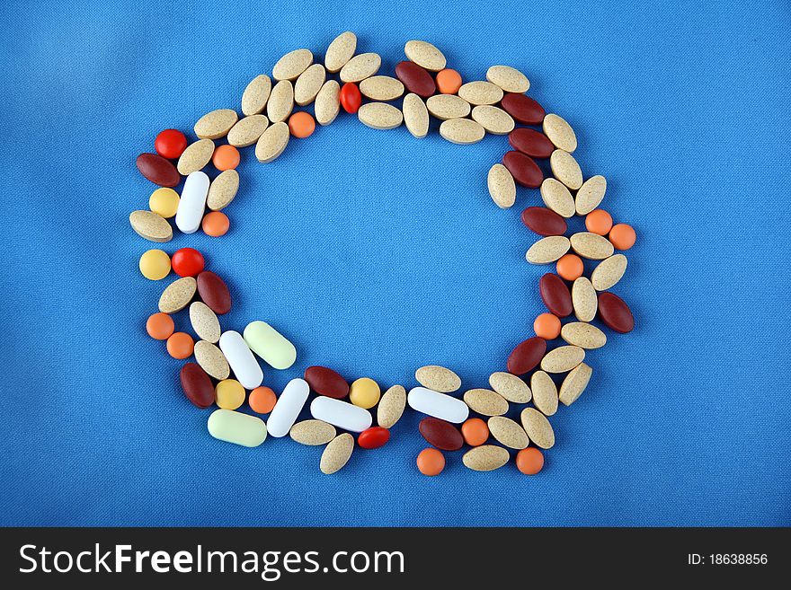 Pills forming a circle shape on blue background. Pills forming a circle shape on blue background