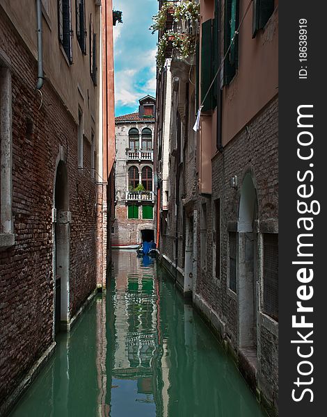 Ordinary Venetian courtyard. Canal. Daylight. Brick wall.