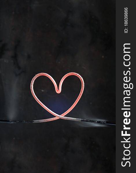 Hot heart made from metal wire isolated on dark background